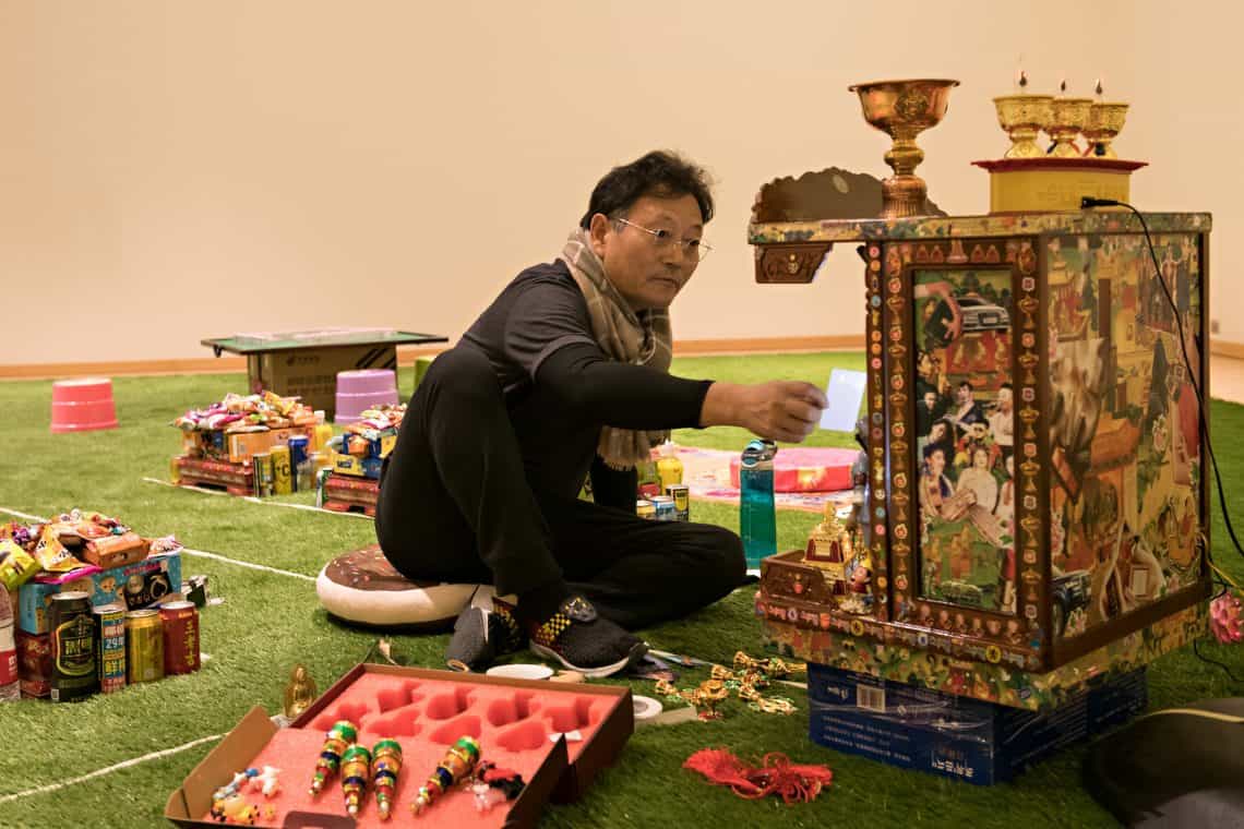 Visiting artist Gonkar Gyatso installing shrine in Staniar Gallery